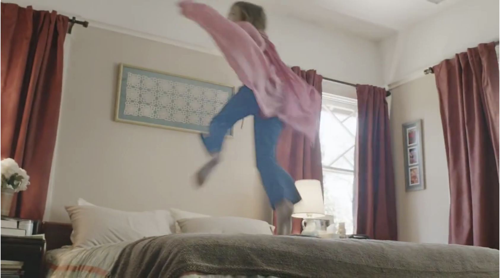 frame with a girl jumping on the bed