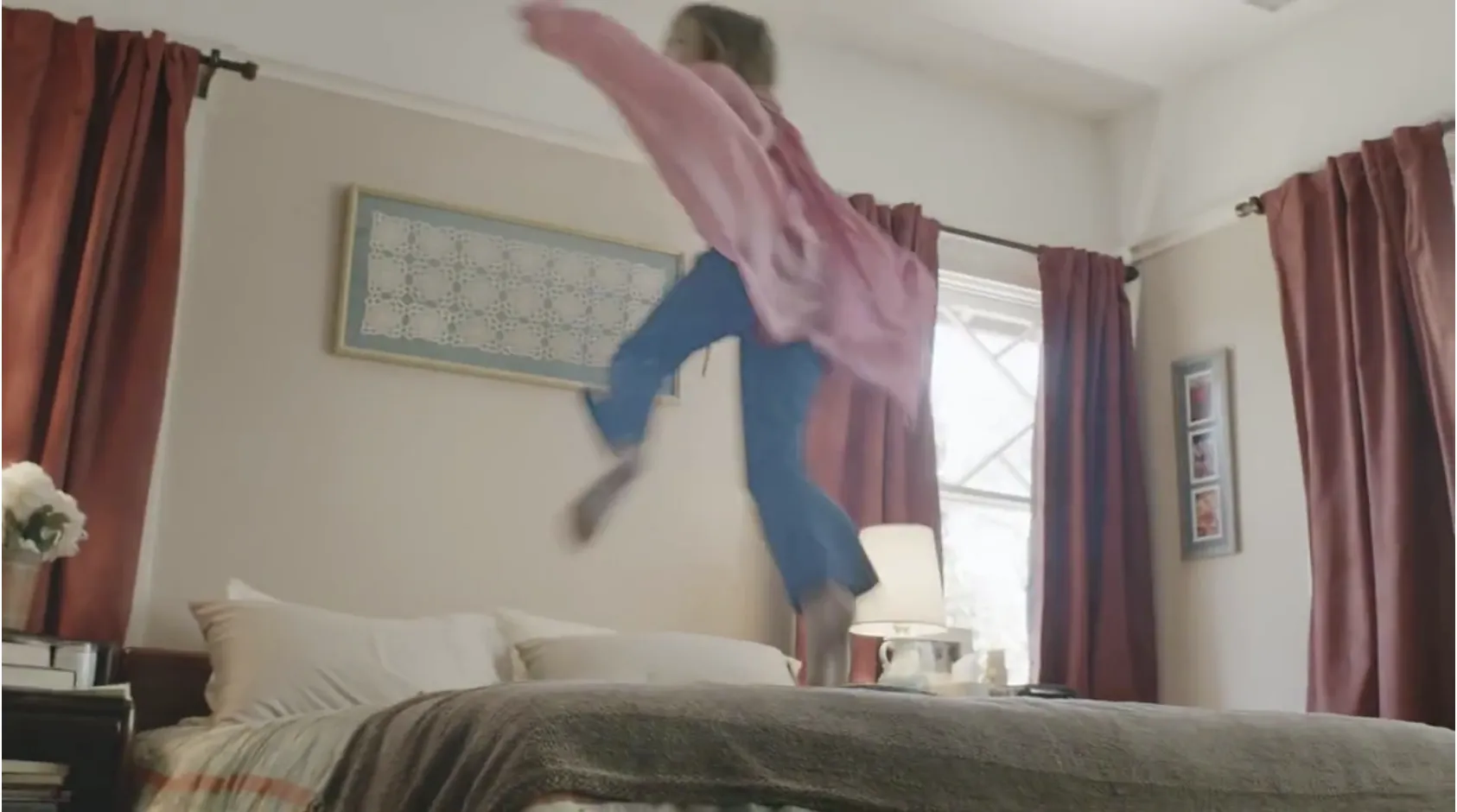 frame with a girl jumping on the bed